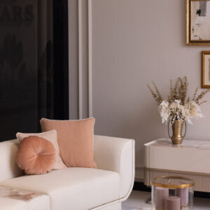 Modern TV unit with a cream high-gloss finish, marble-effect top, fluted detailing, and sleek gold legs, styled in an elegant living room setting.