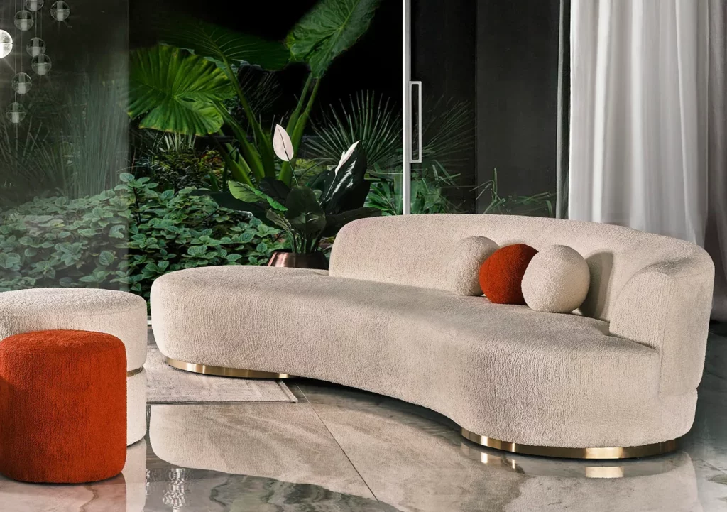 Luxurious Miami Curve Sofa with a curved silhouette, upholstered in custom boucle fabric, set on antique gold bases, featuring a high-quality hornbeam structure and high-density foam for ultimate comfort.