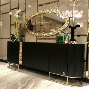 The Lyon Console redefines luxury. Designed with elegance and precision detailing this side unit features a melted gold effect over intricately riveted cupboard doors with co-ordinating metal edged oval mirror.  This stunning piece stretches 2.4 metres in length and is a true statement piece for your living space. Pair this piece with the rest of our Lyon Collection to create a luxurious ensemble. Bespoke made in black, cream or beige gloss and bronze or golden finishing.