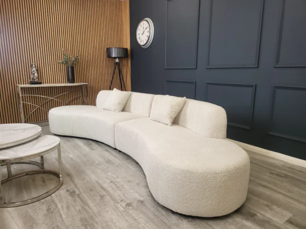 An elegant Bellino 5-seater curved sofa upholstered in luxurious cream bouclé fabric, featuring a smooth, continuous curved design that enhances comfort and adds a modern, sophisticated touch to any living space.