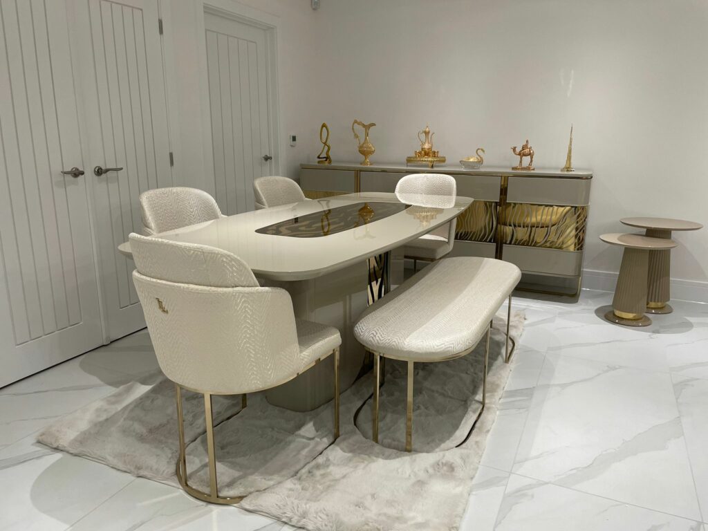 Indulge in the sheer opulence of this cream and gold luxury dining set, where every detail exudes timeless elegance and sophistication. Crafted with impeccable artistry, the exquisite cream upholstery paired with rich gold accents creates a harmonious blend of colors, offering a regal dining experience. The intricately designed table and chairs feature ornate patterns and premium materials, making this dining set a true symbol of luxury and refinement for your dining space.