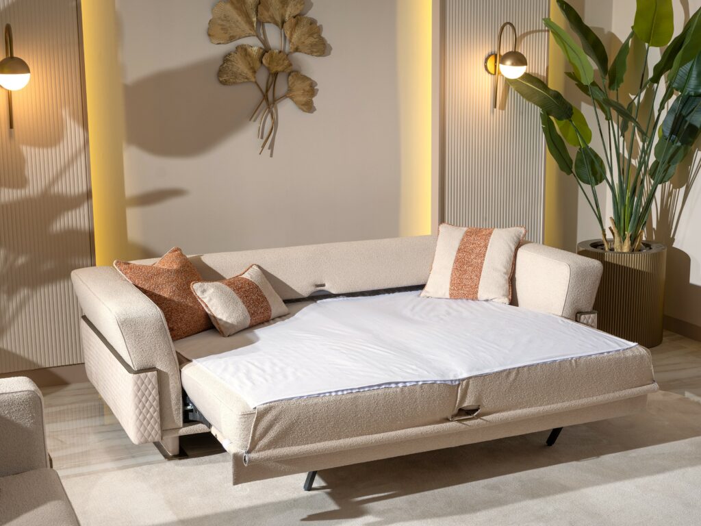 The Imperiale sofa features luxurious sofa bed options. Upholstered in cream with intricate gold detailing, it exudes elegance and versatility in design.