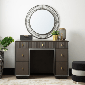 The Amelie Smoke Grey Elm 7 Drawer Dressing Table is a chic furniture piece made of MDF with a sleek veneer finish in an alluring grey tone. This elegant table boasts seven drawers, offering ample storage while exuding modern sophistication, perfect for enhancing any dressing or bedroom space with both style and functionality