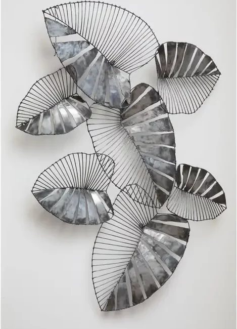 The Zania leaf wall art adds a metallic accent to contemporary interiors. Its leaves are made from a combination of recycled metal and steel wire. The juxtaposition between both materials accentuates the design. The reflective silver finish highlights the intricate detail inherent in nature. Display it in the living room or hallway.