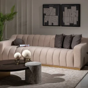 A cream-colored modern sofa featuring a sleek design with a luxurious gold plinth base, providing a sophisticated and elegant look suitable for contemporary interior settings.