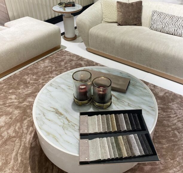 Round Odyssey Coffee Table in beige with tinted glass top and elegant gold plinth base