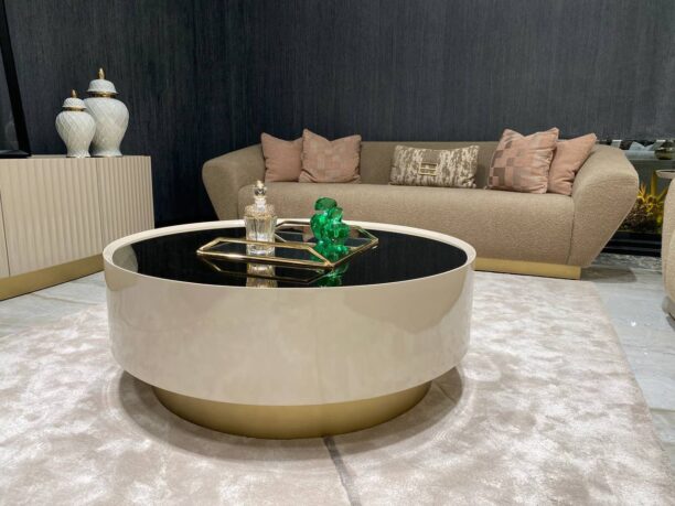 Round Odyssey Coffee Table in beige with tinted glass top and elegant gold plinth base