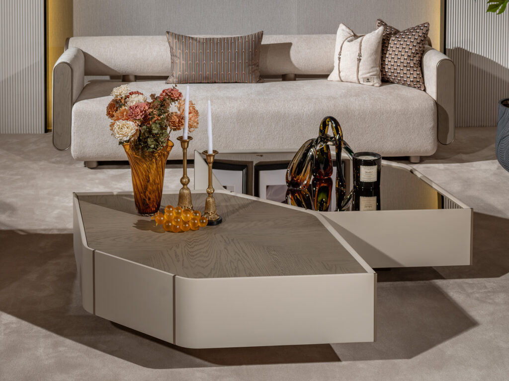 A set of two luxurious Sovrano coffee tables featuring a hexagon silhouette; one with a wooden top and the other with a glass top. Each table includes antique gold detailing, perfect for a sophisticated and abstract modern living room design.