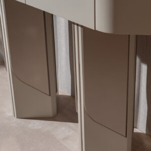 A sleek, abstract console table with a matching mirror, featuring a smooth beige finish and modern design, perfectly complementing a sophisticated interior decor.