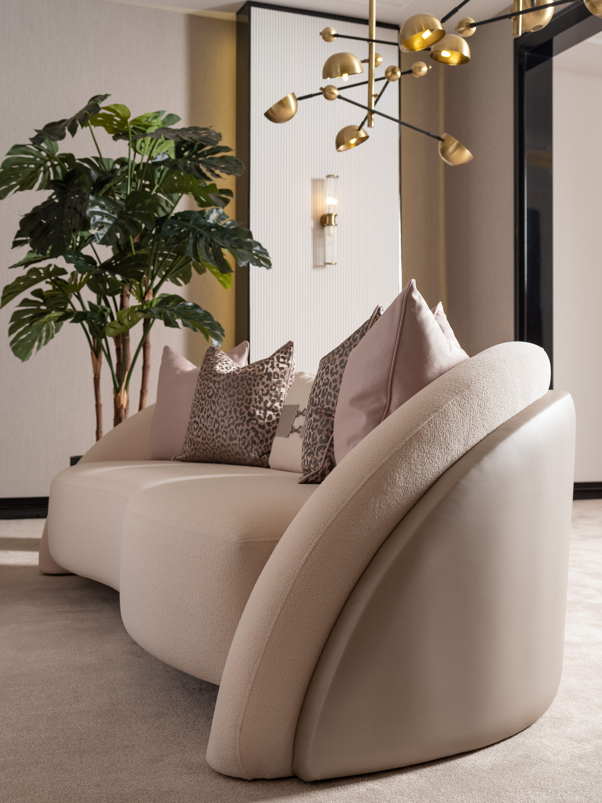 Bespoke Liora Sofa with a curved silhouette, plush upholstery, and a leather-wrapped back, available in various colors to match any home décor, showcasing luxury and modern design.