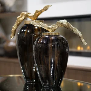 Make a bold statement with the Arlo Grande Decorative Jar, a stunning piece that beautifully blends rich chocolate and ebony tones. Its luxurious glazed finish is perfectly complemented by an elegant gold lid, creating a sophisticated focal point for any console or shelf.