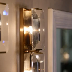 The Belgravia Wall Light exudes boldness and glamour, making it a standout piece for any room. Crafted with faceted crystal prisms and brass, it beautifully reflects and refracts light, reminiscent of emerald-cut diamonds. This luxurious crystal and brass wall light is the perfect addition to any space, combining timeless elegance with modern sophistication.