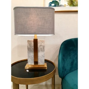 The Elisa Brass & Marble Table Lamp brings a sleek and contemporary touch to any room. Standing at 59cm, it features a stunning grey marble-inspired base with natural grain details, enhanced by elegant brass accents. The warm, rich slate grey linen shade adds a sophisticated contrast, making it a perfect fit for modern interiors.