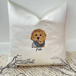 Handcrafted Pawtrait Cushion with custom pet embroidery on warm white fabric, featuring invisible zip fastening and luxurious feather insert.