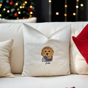 Handcrafted Pawtrait Cushion with custom pet embroidery on warm white fabric, featuring invisible zip fastening and luxurious feather insert.