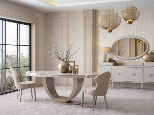 Sophisticated dining room featuring the cream Lusso dining set with a bronze-accented oval table, plush chairs, and a matching sideboard, complemented by golden decor and modern pendant lighting, in a neutral-toned interior.