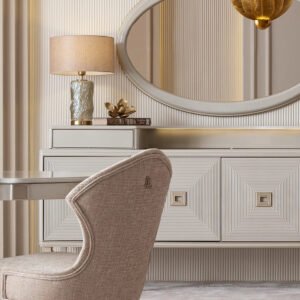 Sophisticated dining room featuring the cream Lusso dining set with a bronze-accented oval table, plush chairs, and a matching sideboard, complemented by golden decor and modern pendant lighting, in a neutral-toned interior.