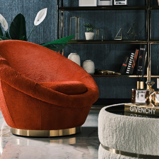 Miami Armchair featuring bold curves, plush orange bouclé upholstery, and a gold circular base, perfect for contemporary luxury interiors.