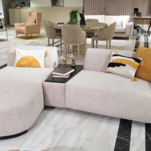 Amalfi corner chaise sofa in a luxurious neutral fabric with optional built-in wooden table, accented with plush cushions and modern Italian-inspired design, set in a contemporary living room