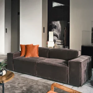 Elegant Sierra Sofa in a light fabric finish, accented with rust-colored scatter cushions, displayed in a contemporary living room.