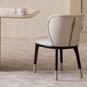 Valentina Dining Chair with curved back, black legs, and gold-tipped feet—refined elegance with bespoke fabric options.